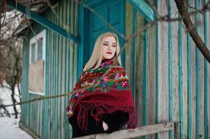 fille blonde avec écharpe brodée à la main posée au jour d'hiver. mouchoir femme. photo