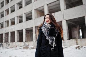 brune élégante fille décontractée en écharpe contre la place de l'usine abandonnée. photo