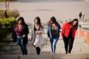 groupe de quatre filles latinos heureuses et jolies de l'équateur posées dans la rue. photo