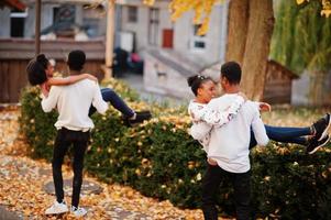 quatre amis africains marchant dans les rues d'une ville antique à la journée ensoleillée d'automne. photo