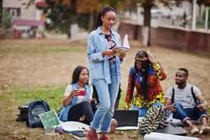 groupe de cinq étudiants africains qui passent du temps ensemble sur le campus de la cour universitaire. amis afro noirs qui étudient. thème de l'éducation. photo