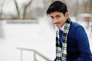 homme étudiant indien élégant en costume et écharpe posé à la journée d'hiver en plein air. photo