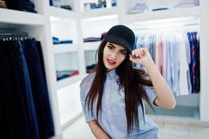 fille magnifique brune dans la boutique de vêtements décontractés et casquette. photo