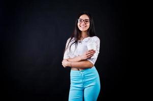 portrait d'une jeune femme heureuse en haut blanc et pantalon bleu avec une tasse de café à la main. photo