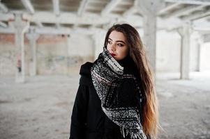 brune élégante fille décontractée en écharpe contre la place de l'usine abandonnée. photo