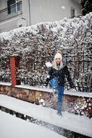 fille blonde s'amusant avec la neige le jour de l'hiver. photo