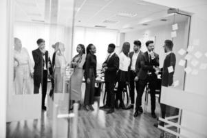 grand groupe de onze hommes d'affaires multiraciaux debout au bureau. groupe diversifié d'employés en tenue de soirée. photo