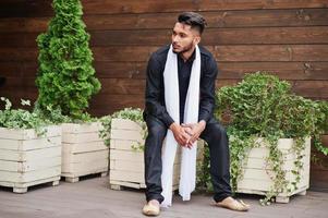 homme élégant indien en vêtements traditionnels noirs avec foulard blanc posé à l'extérieur. photo