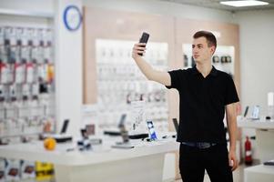 vendeur homme consultant professionnel en téléphonie mobile dans un magasin de technologie ou un magasin. photo