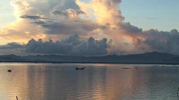 pêcheur sur son bateau au coucher du soleil. bateau de pêcheurs au coucher du soleil photo