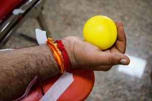 donneur de sang au camp de don de sang tenu avec une balle gonflable tenant dans la main au temple balaji, vivek vihar, delhi, inde, image pour la journée mondiale du don de sang le 14 juin de chaque année, camp de don de sang photo