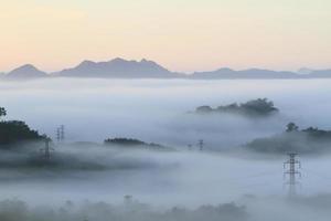 nuages dramatiques avec montagne et arbre le matin photo