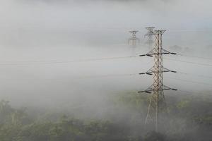lignes électriques et pylônes émergeant de la brume photo