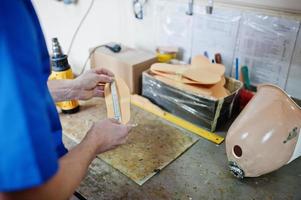 homme prothésiste fabriquant des semelles orthopédiques tout en travaillant en laboratoire. photo