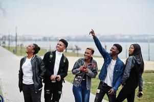 jeunes amis africains de la génération Y marchant dans la ville. des noirs heureux s'amusant ensemble. concept d'amitié génération z. photo