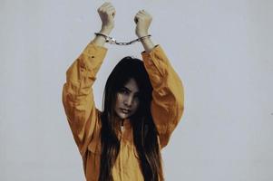 concept de prisonnier en robe orange, portrait d'une femme asiatique en uniforme de prison sur fond blanc, photo