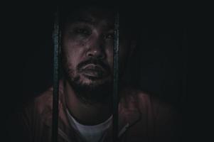 homme asiatique désespéré à la prison de fer, concept de prisonnier, peuple thaïlandais, espoir d'être libre, prisonniers sérieux emprisonnés dans la prison photo