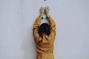 concept de prisonnier en robe orange, portrait d'une femme asiatique en uniforme de prison sur fond blanc, photo