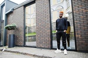 l'homme aux cheveux rouge africain porte une tenue noire posant à l'extérieur. photo