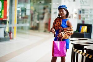 belle dame afro-américaine avec des sacs à provisions sur le centre commercial. photo