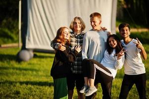 jeune groupe multiethnique de personnes regardant un film au pouf dans un cinéma en plein air. photo