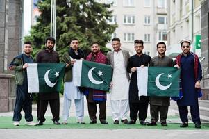 groupe d'hommes pakistanais portant des vêtements traditionnels salwar kameez ou kurta avec des drapeaux pakistanais. photo