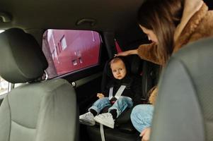 jeune mère et enfant en voiture. siège bébé sur chaise. concept de conduite de sécurité. photo