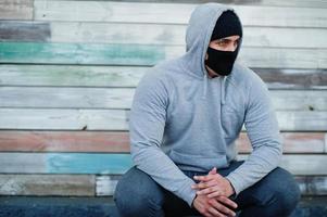 portrait sport arabe homme en masque médical noir et sweat à capuche pendant la quarantaine du coronavirus. photo