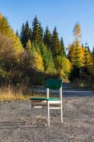 Chaise en bois blanc unique à l'extérieur sur du gravier photo