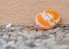 clémentine ou mandarine à moitié pelée sur gravier photo