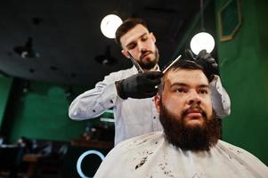 bel homme barbu au salon de coiffure, coiffeur au travail. photo