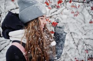 portrait de jeune fille au jour de neige d'hiver près des arbres couverts de neige. photo