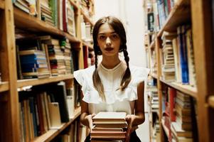 fille avec des nattes en blouse blanche à l'ancienne bibliothèque. photo