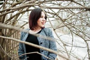 portrait de jeune fille brune en robe noire au bois de printemps. photo