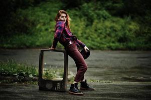 portrait de mode de fille sexy rousse en plein air. modèle séduisante femme dramatique avec une vieille boîte de télévision. photo