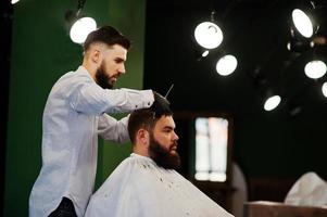 bel homme barbu au salon de coiffure, coiffeur au travail. photo