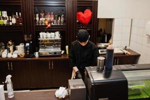 chef professionnel porter en noir faisant des sushis et des petits pains dans une cuisine de restaurant de cuisine traditionnelle japonaise. photo