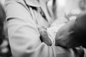 jambe de nouveau-né au baptême rituel. noir et blanc. photo