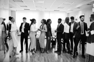 grand groupe de onze hommes d'affaires multiraciaux debout au bureau. groupe diversifié d'employés en tenue de soirée. photo