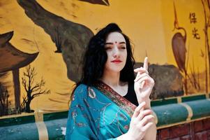 portrait d'une belle fille de brumette indienne ou d'un modèle de femme hindoue contre un mur de graffitis japonais. photo