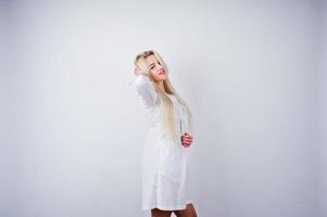 jolie blonde femme médecin ou infirmière en blouse de laboratoire isolée sur fond blanc. photo