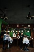 bel homme barbu au salon de coiffure, coiffeur au travail. photo