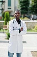 médecin afro-américain mâle en blouse de laboratoire avec stéthoscope en plein air. photo