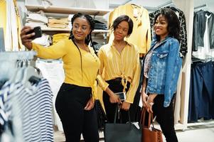 trois femmes africaines au magasin de vêtements. jour et heure de shopping pour selfie. photo