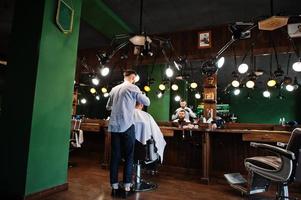 bel homme barbu au salon de coiffure, coiffeur au travail. photo