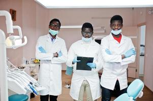 trois médecins afro-américains travaillant, posant avec des collègues dans une clinique dentaire. photo