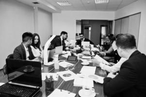 jeunes créatifs multiraciaux dans un bureau moderne. groupe de jeunes gens d'affaires travaillent avec un ordinateur portable, une tablette. équipe de pigistes à succès dans le coworking. photo