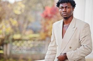 homme afro élégant en costume beige old school. jeune homme africain à la mode en veste décontractée sur torse nu. photo