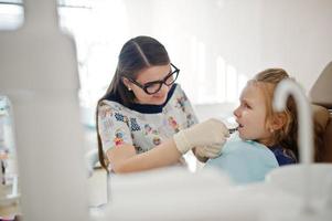 petite fille au fauteuil de dentiste. enfants dentaires. photo