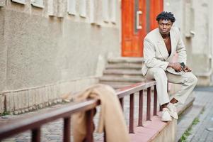 homme afro élégant en costume beige old school. jeune homme africain à la mode en veste décontractée sur torse nu. photo